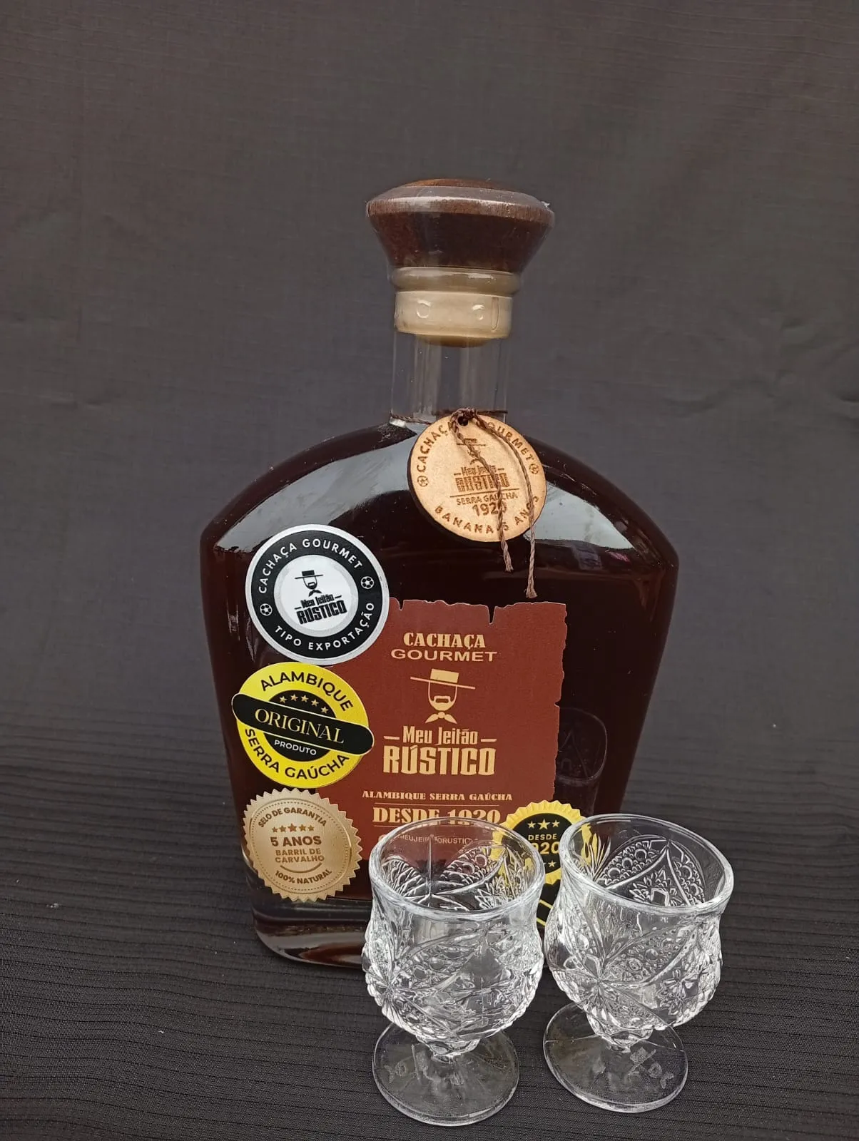 Kit com garrafa de cachaça premium sabor banana de 750 ml e dois copos de vidro