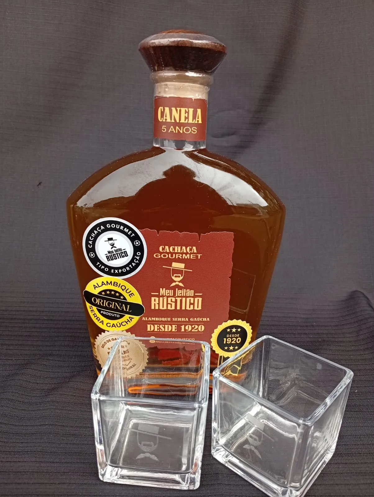 Kit com garrafa de cachaça premium sabor canela de 750 ml e dois copos de vidro