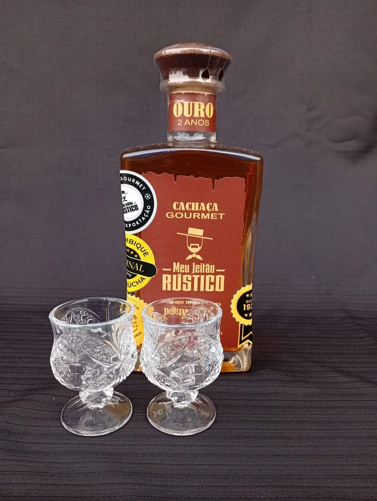 Kit com garrafa de cachaça premium sabor ouro de 750 ml e dois copos de vidro